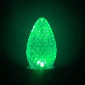 C7 faceted green holiday bulb close-up on black background